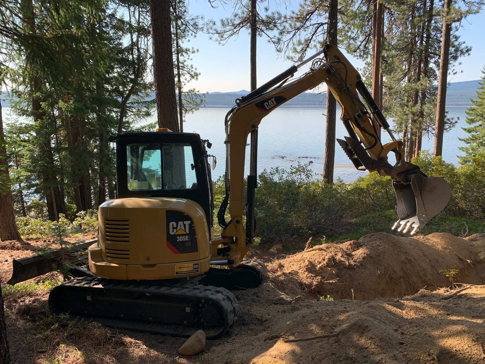 Leonardo Excavation CAT excavator digging above a Cascade lake near La Pine, Oregon